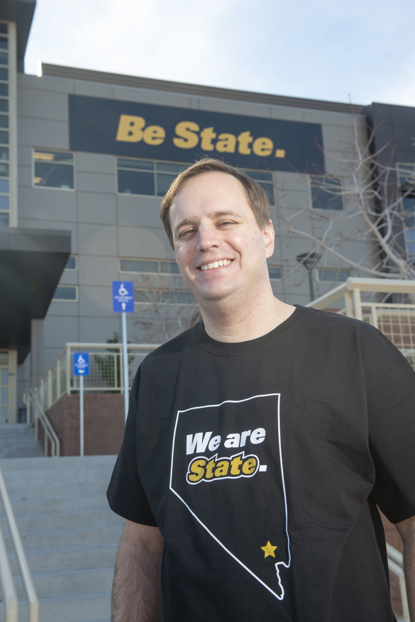 A man wearing a We Are State shirt