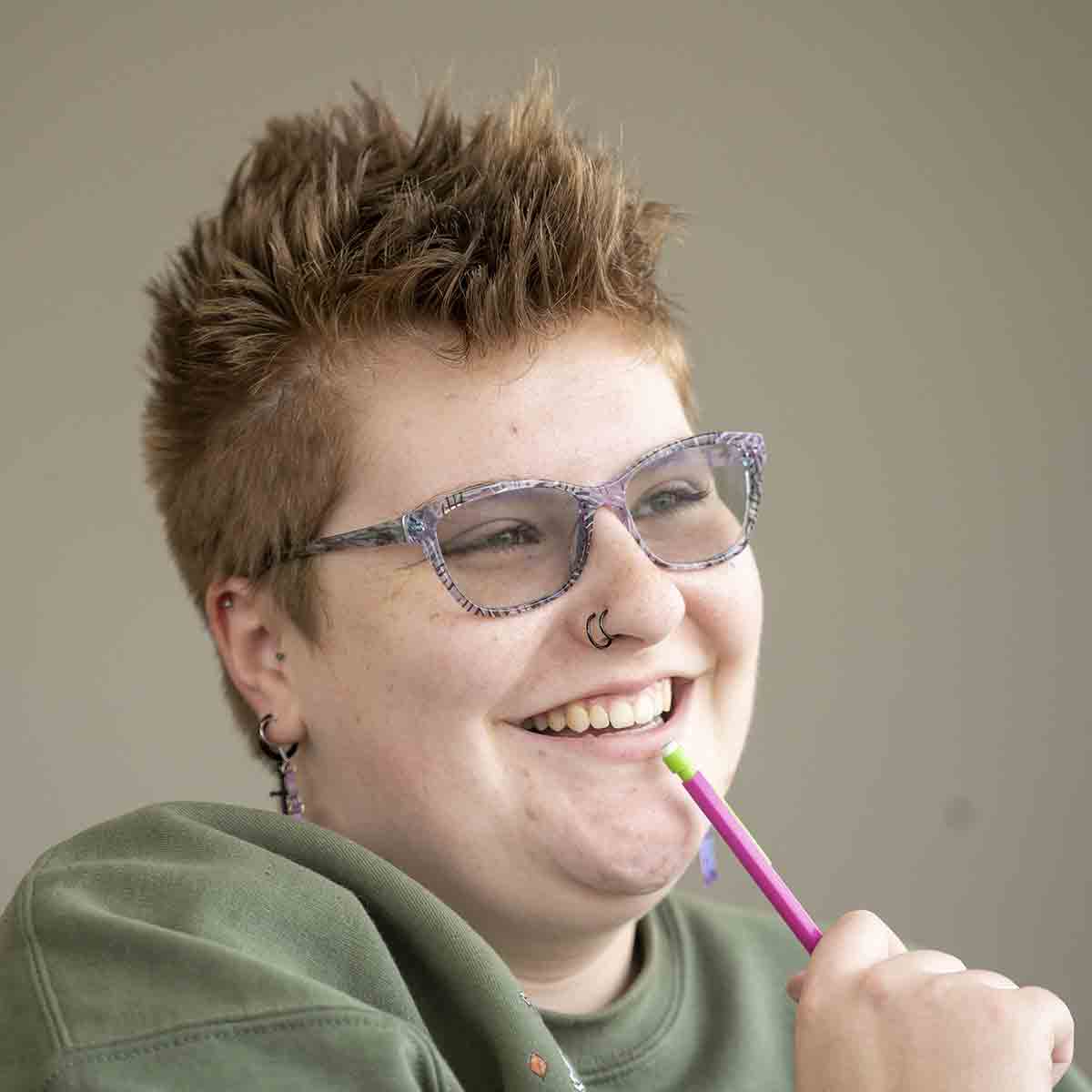 student holding pink pencil