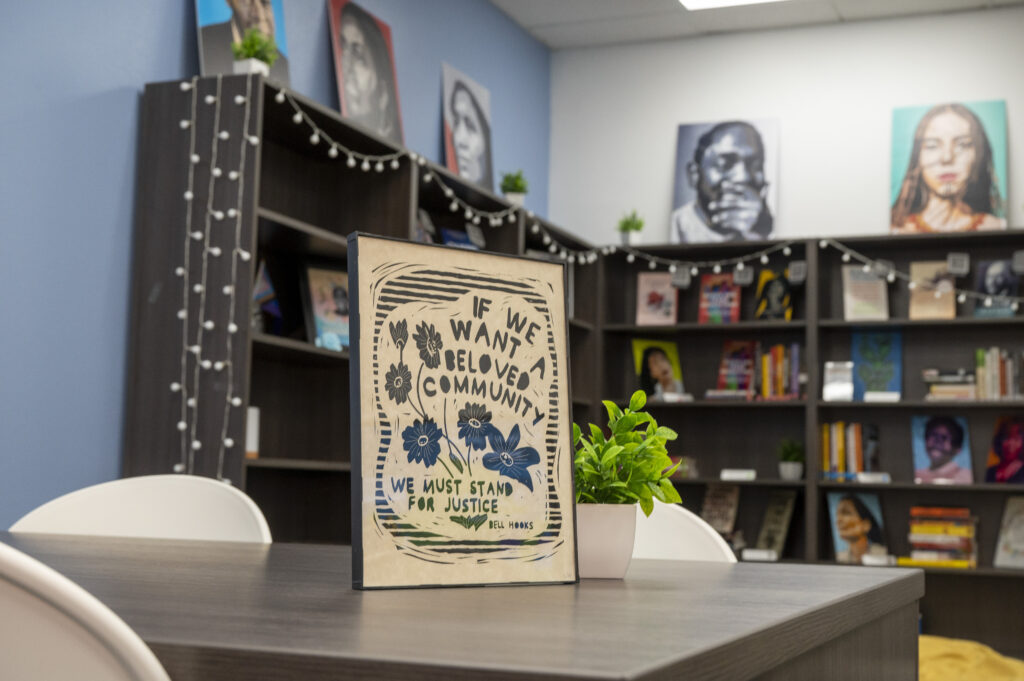 Wooden plaque with flowers saying "If We Want A Beloved Community We Must Stand For Justice"