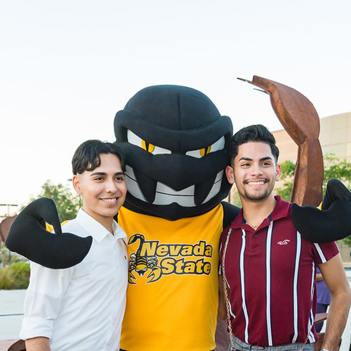 2 students posing with sting mascot