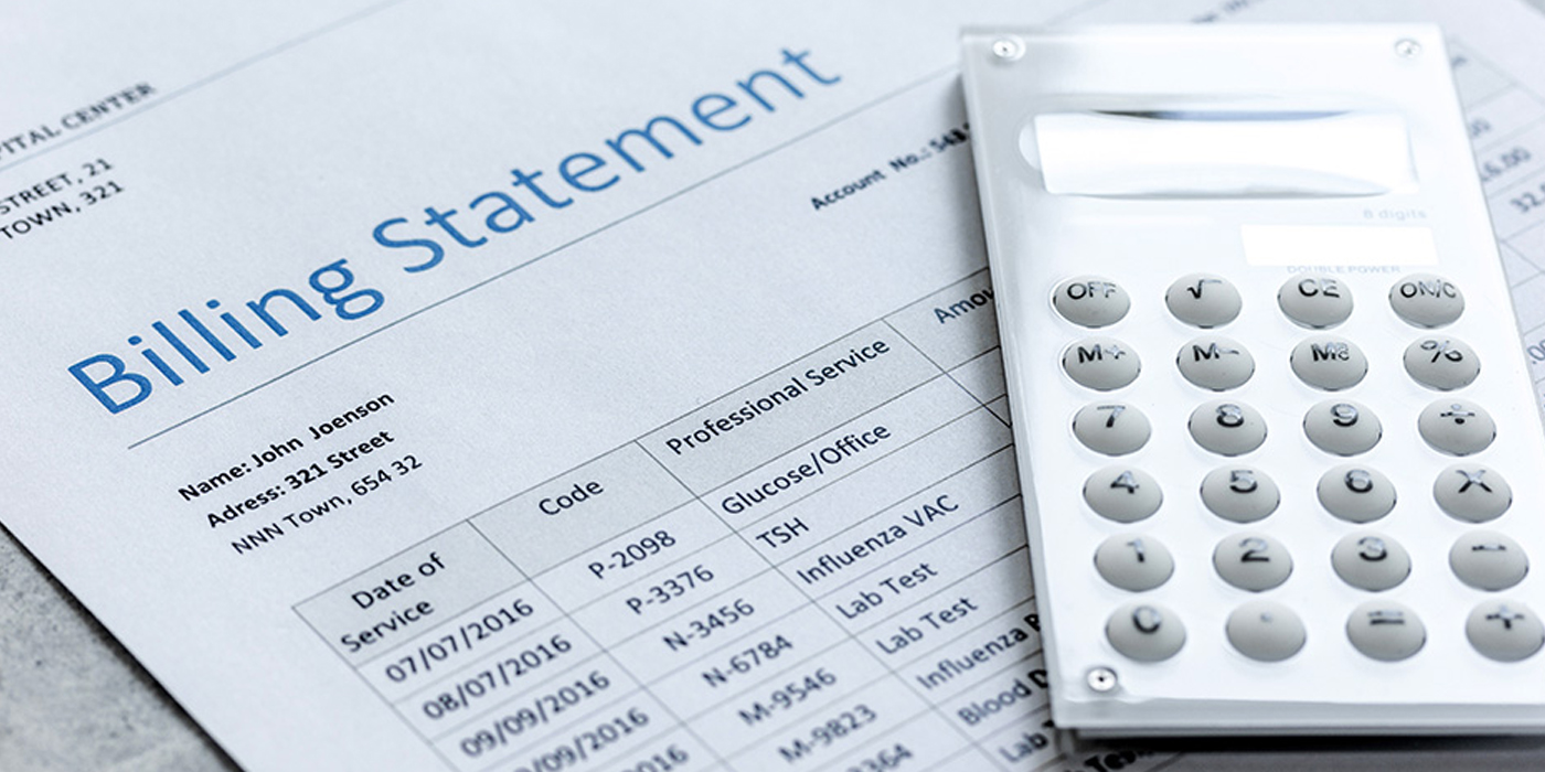 Calculator and billing statement spread out on a desk