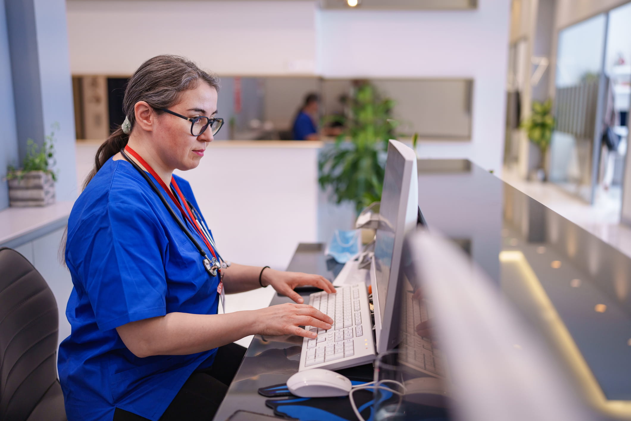 Public health nurse working at a computer to document patient and community health information.