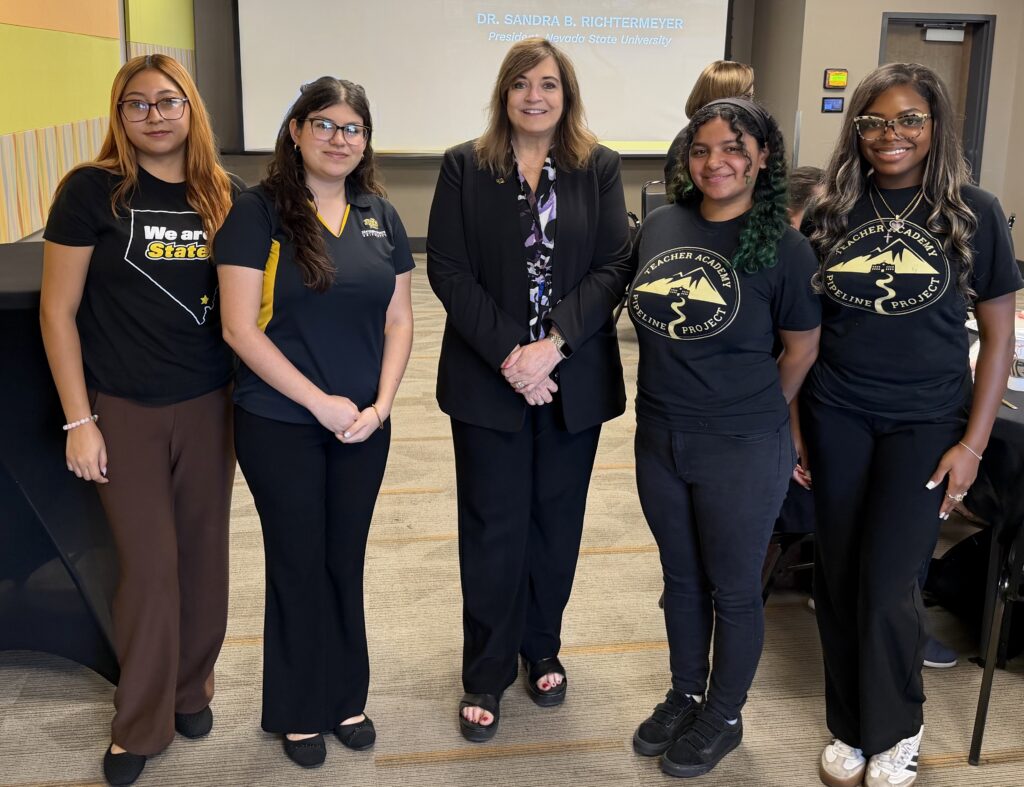 Nevada State University President Dr. Sandra B. Richtermeyer stands with four student volunteers at the second annual Education Summit.